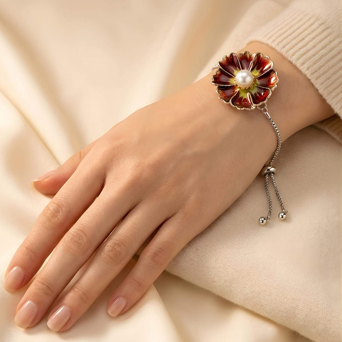 Tragebild des Premium Blumen-Druckknopfs 18mm "Amber Glow" (Braun-Gelb) montiert auf einem Armband. Die braune Blüte mit Perle zeigt die Wirkung des KLIQs als eleganter Armschmuck.