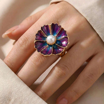 Tragebild des lila-blauen Blumen-Druckknopfs "Mystic Violet" montiert auf einem silbernen KLIQ-Ring. Die 18mm Blüte mit Perle zeigt die Wirkung des KLIQs als Ring-Schmuckstück.
