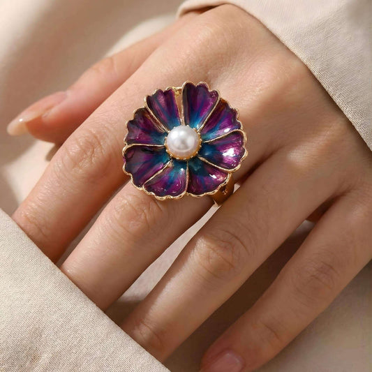 Tragebild des lila-blauen Blumen-Druckknopfs "Mystic Violet" montiert auf einem silbernen KLIQ-Ring. Die 18mm Blüte mit Perle zeigt die Wirkung des KLIQs als Ring-Schmuckstück.