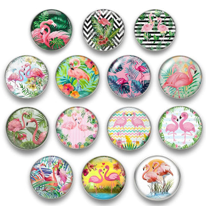 Übersicht der 14 Tropical Flamingo KLIQs 18mm Kollektion, mit runden Glas-Druckknöpfen in verschiedenen tropischen, floralen und geometrischen Mustern (z.B. Dschungel, Zick-Zack, Blumen, Palmen)